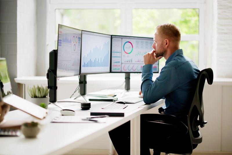 A business owner reviews fuel card usage of his fleet in real-time at his desktop computer in his office.