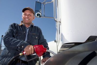 Truck driver fueling semi truck with fleet fuel card
